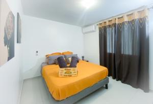 1 dormitorio con 1 cama amarilla en una habitación en KAZ'ANTILLAISE TI LUCA APPARTEMENT 3/4 PERS., en Le Lamentin