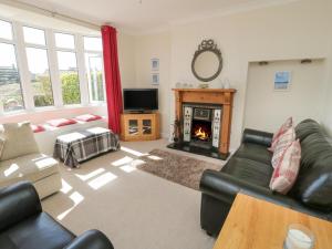 a living room with a couch and a fireplace at The Nook in Benllech