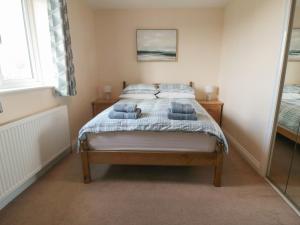 ein Schlafzimmer mit einem Bett mit blauen Decken und Kissen in der Unterkunft Cherry Garth in Whitby