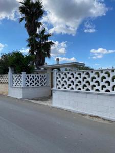 une clôture blanche devant une maison dans l'établissement Villa Viola, à Torre Chianca