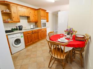 a kitchen with a table with a red table cloth at Westmount in Ryde