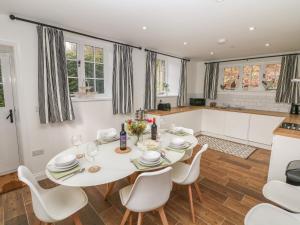 a kitchen and dining room with a white table and chairs at Willow Cottage in Sheffield