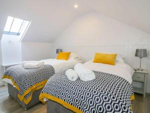 two twin beds in a room with a window at Apple Barn in Newquay