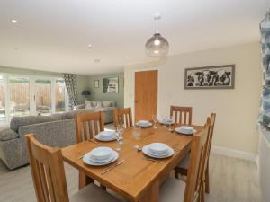 a dining room with a wooden table and chairs at Bramley Cottage in Langport