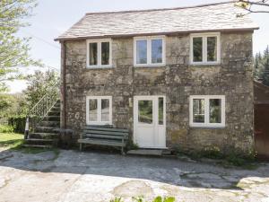 a stone house with a bench in front of it at Little Trespettigue in Launceston