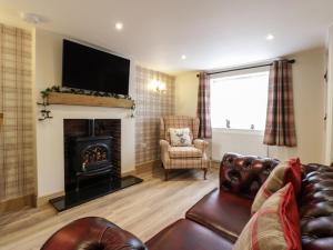 a living room with a couch and a fireplace at Cosynook Cottage in Blandford Forum