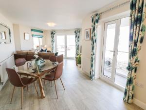 een eetkamer en een woonkamer met een tafel en stoelen bij Ocean View Apartment in Colwyn Bay