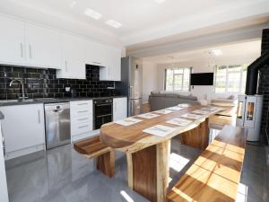 a kitchen with a long wooden table in it at Castle Top Retreat in Market Rasen