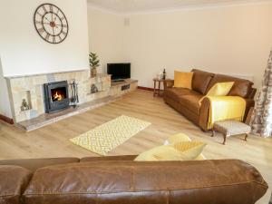 a living room with a couch and a fireplace at Cwm heulog in Abergele