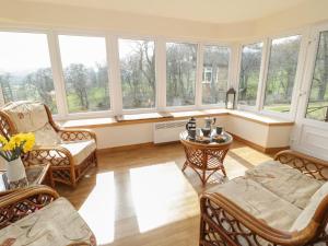 a living room with a lot of windows at Cwm heulog in Abergele