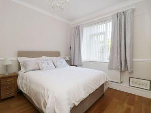 a white bedroom with a large bed and a window at Castle Top Retreat in Market Rasen