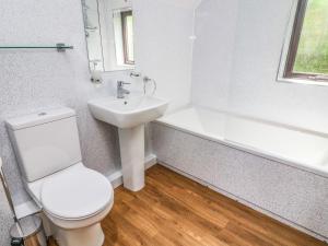 a bathroom with a toilet and a sink and a bath tub at The Coach House in Carnforth +15 photos