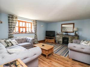 - un salon avec deux canapés et une cheminée dans l'établissement Foxglove Cottage, à Whitland