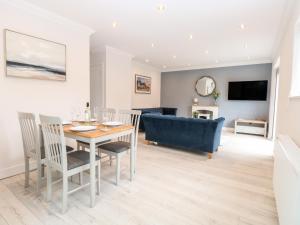 a dining room and living room with a table and chairs at Harbour Place in Wells next the Sea