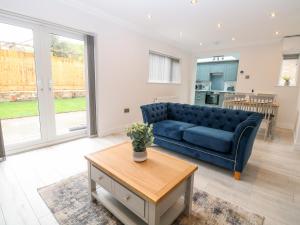 a living room with a blue couch and a table at Harbour Place in Wells next the Sea