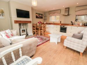 - un salon avec un canapé, des chaises et une table dans l'établissement Swainby Cottage, à Northallerton