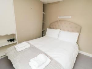 a bedroom with a white bed with two towels on it at Swainby Cottage in Northallerton