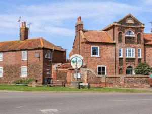 a brick building with a clock on the side of it at Harbour Place in Wells next the Sea