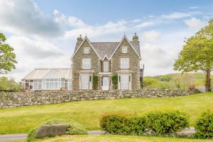 una gran casa de ladrillo con una pared de piedra en Ael Y Bryn Country House, en Dyffryn