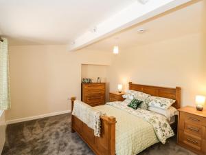 a bedroom with a bed and a dresser at The Old Cow Shed in Banwell