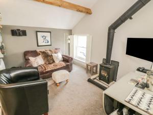 - un salon avec un canapé et un poêle à bois dans l'établissement Dibble Cottage, à Richmond