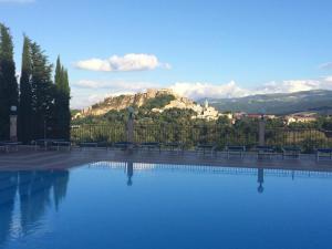 a pool with benches and a mountain in the background at Hotel Ambasciatori in Calitri