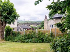a garden with a bridge in the background at Mischa Cottage in Bradford