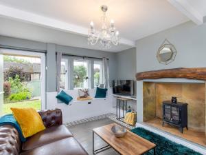 Mischa Cottage في برادفورد: غرفة معيشة مع أريكة ومدفأة