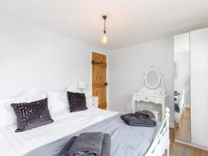 a bedroom with a white bed with towels on it at Mischa Cottage in Bradford