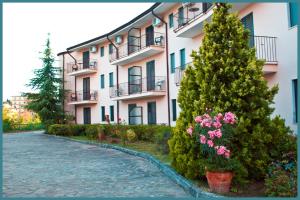 a building with two trees and flowers in front of it at Hotel Ambasciatori in Calitri