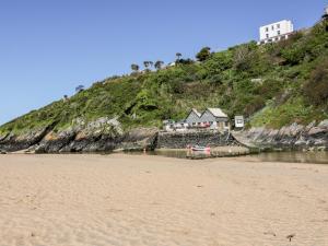 a house on top of a hill next to a beach at Tresawle in Newquay