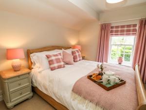 ein Schlafzimmer mit einem Bett und einem Tablett mit Essen drauf in der Unterkunft Church Cottage in Bakewell