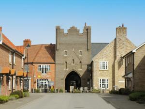 an old brick building with a gate in a street at 2 Perran Court in Filey