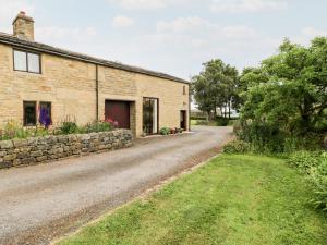 an old stone house with a gravel road at The Barn at Heath Hall Farm in Sowerby Bridge