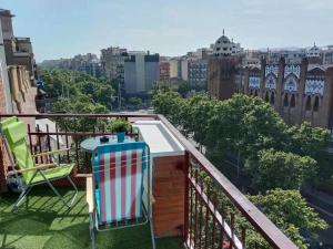 balkon z 2 krzesłami i widokiem na miasto w obiekcie Apartament Sagrada Familia w Barcelonie