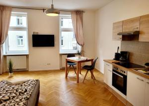 een keuken met een tafel en een kleine tafel en stoelen bij Buchengasse Apartment Vienna - Free Highspeed-Internet in Wenen