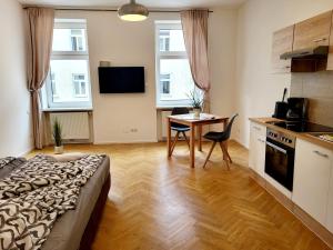 een kamer met een keuken, een tafel en een bed bij Buchengasse Apartment Vienna - Free Highspeed-Internet in Wenen +35 foto's