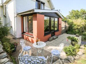 a patio with a table and chairs in front of a house at Barley Cottage in Mydroilin