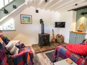 a living room with a wood stove at Barley Cottage in Mydroilin
