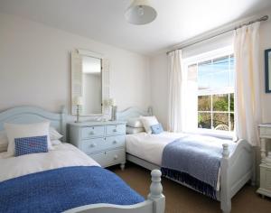 a bedroom with two beds and a sink and a window at Castaway in Port Isaac