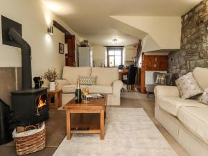 a living room with a fireplace and a stove at Sandholme Cottage in Skipton