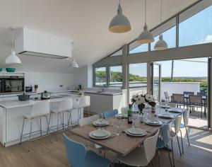 a dining room and kitchen with a table and chairs at Point Break in Polzeath
