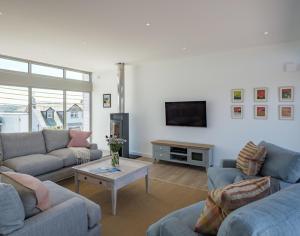 a living room with two couches and a tv at Point Break in Polzeath