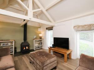 a living room with a fireplace and a flat screen tv at Lavender Barn in Newquay