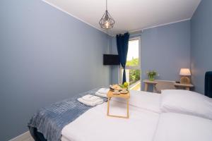 a bedroom with a white bed with a table on it at Maya's Flats & Resorts 52 - Aura 40 in Gdańsk