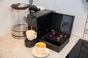a microwave with two cups of coffee and a blender at Maya's Flats & Resorts 52 - Aura 40 in Gdańsk