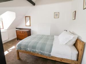 a bedroom with a bed and a dresser at Manor Farm Cottage in Worcester