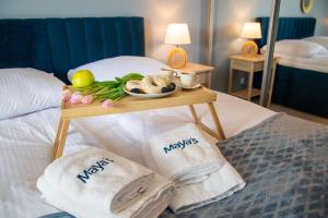 a tray of food on a table on a bed at Maya's Flats & Resorts 52 - Aura 40 in Gdańsk