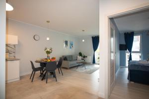 a kitchen and living room with a table and chairs at Maya's Flats & Resorts 52 - Aura 40 in Gdańsk