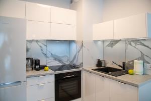 a kitchen with white cabinets and a sink at Maya's Flats & Resorts 52 - Aura 40 in Gdańsk